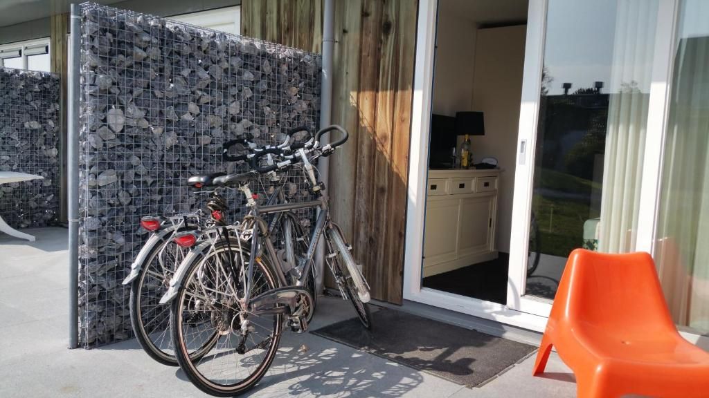 Cycling by the terrace of Apartment Amelander-Kaap TIME-OUT with SWIMMING POOL, Hollum, Ameland, for an active vacation.