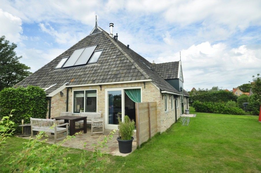 Buitenzijde van Appartementenboerderij de Hek Oost in Hoorn, Terschelling met terras en tuin.