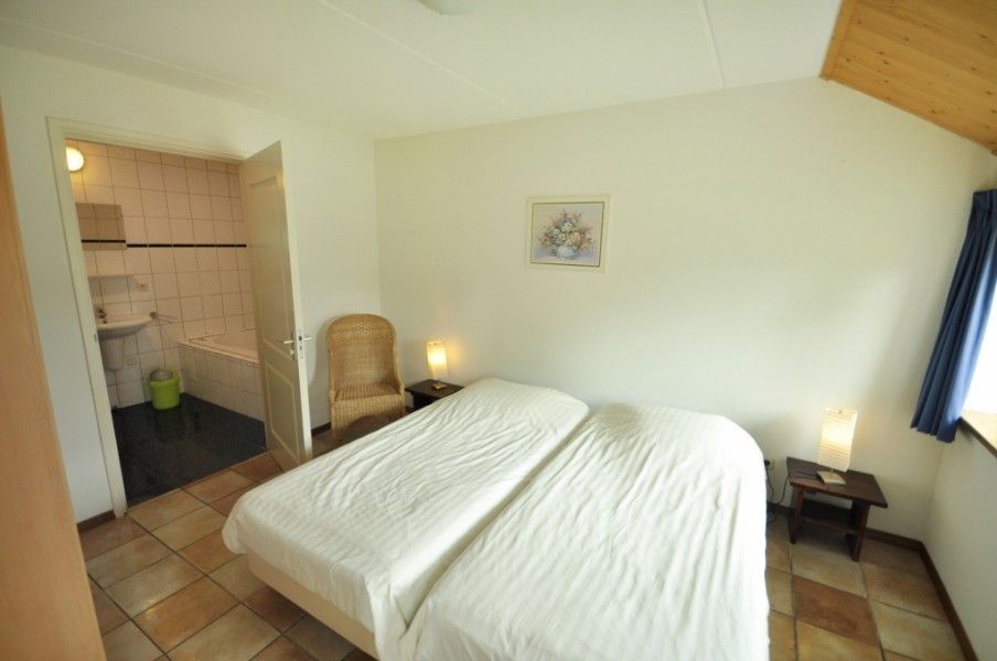 Tweede slaapkamer in Appartementenboerderij de Hek Oost, Hoorn, Terschelling met aangrenzende badkamer.