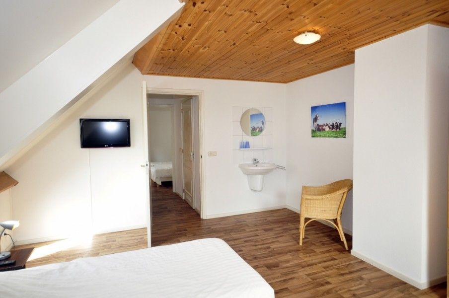 Slaapkamer met wastafel in Appartementenboerderij de Hek Oost, Hoorn, Terschelling voor extra comfort.