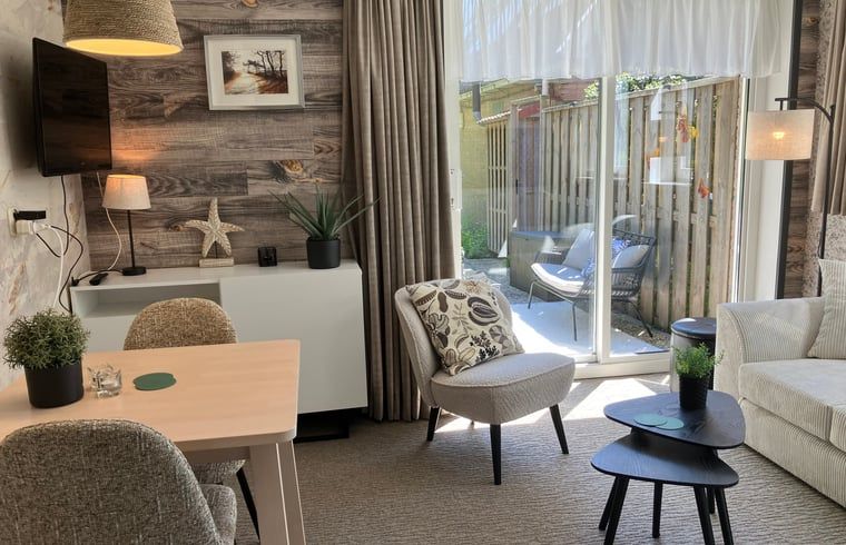 Lichte woonkamer van Huisje in Oosterend met uitzicht op het terras, Terschelling, Waddeneilanden.
