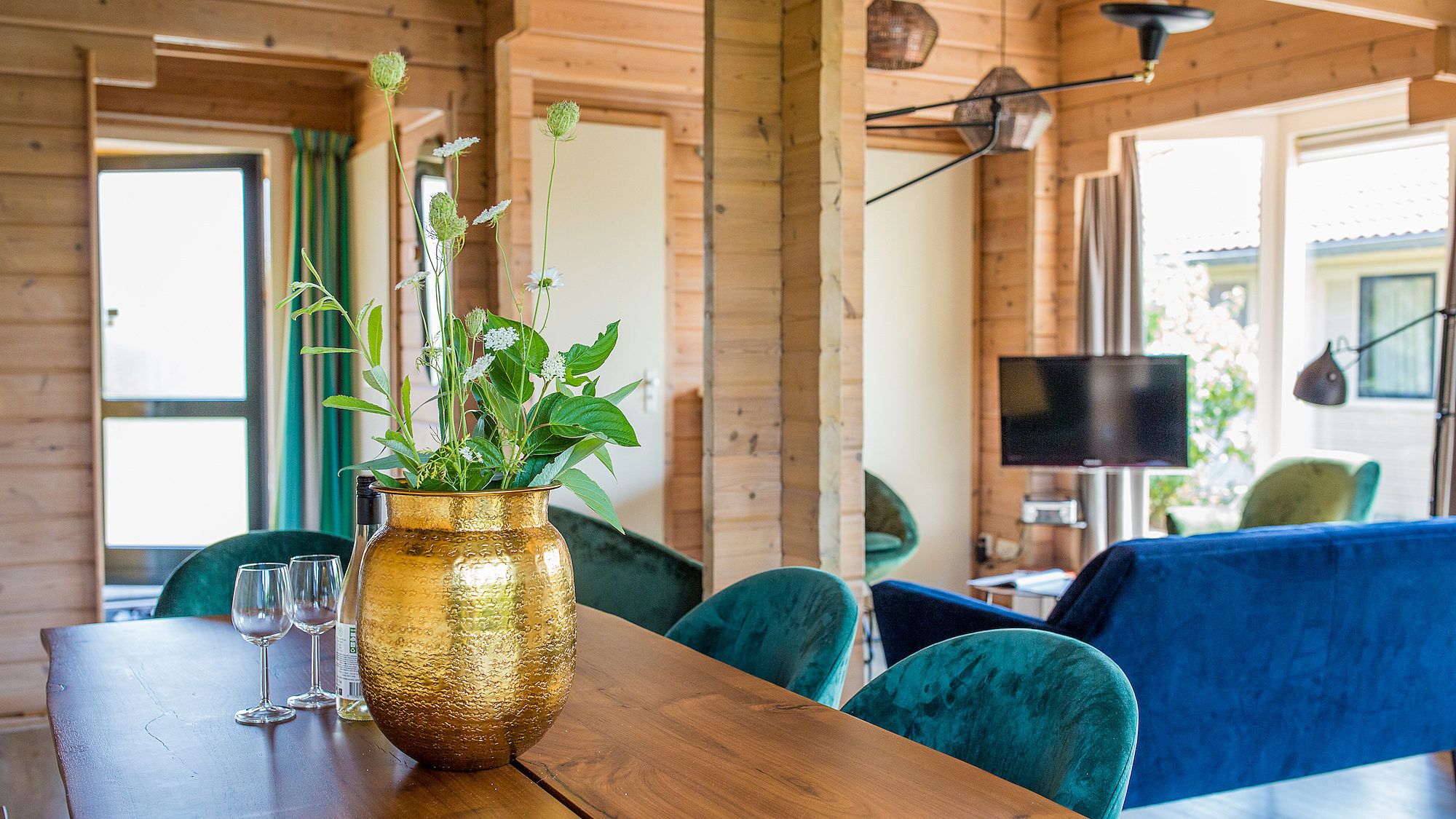 Stijlvolle eetkamer in Villabungalow, vakantiehuis in Oosterend, Terschelling, met houten details en groene accenten op de Waddeneilanden.