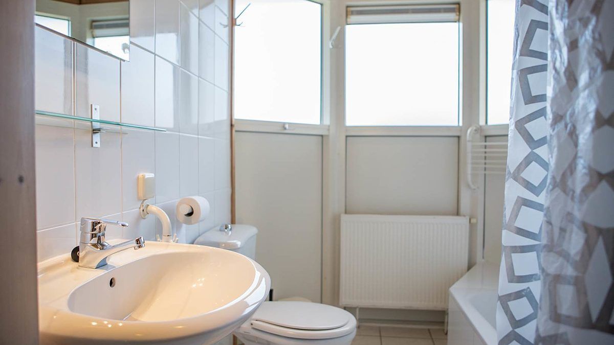 Moderne badkamer in Villabungalow, vakantiehuis in Oosterend, Terschelling, met lichte tegels en ruime douche op de Waddeneilanden.