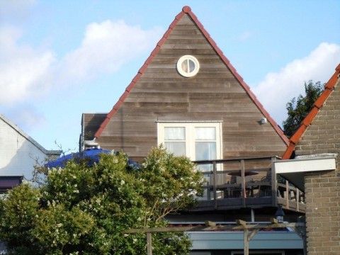 Charmant appartement Havenzicht met houten gevel in West, Terschelling, ideaal voor een ontspannen verblijf op de Waddeneilanden.