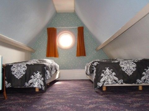Ruime slaapkamer met dakraam in appartement Havenzicht, West, Terschelling, biedt comfort en rust op de Waddeneilanden.