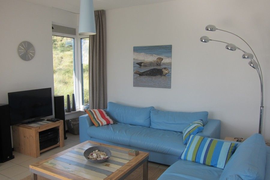 Gezellige woonkamer in Nij Jit vakantiehuis, Midsland aan Zee Terschelling, met comfortabele banken.