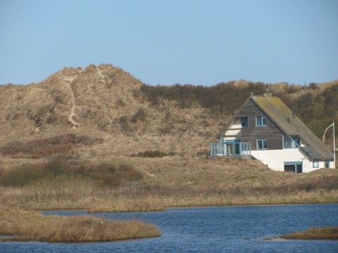 Nij Jit vakantiehuis aan een meer in Midsland aan Zee Terschelling, omgeven door duinen.