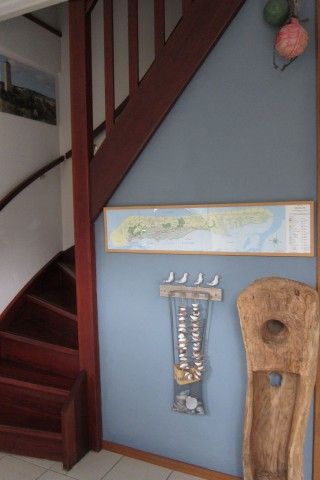 Sfeervolle hal in Nij Jit vakantiehuis, Midsland aan Zee Terschelling, met houten trap en decoratie.