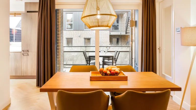 Eetkamer van 4-persoons appartement 4C1 in West-Terschelling met uitzicht op balkon, Waddeneilanden.