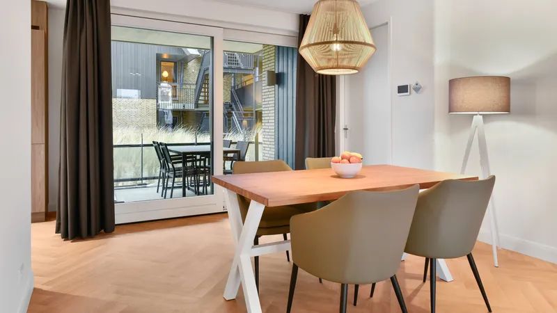 Stijlvolle eetruimte van 4-persoons appartement 4C1 in West-Terschelling, met toegang tot balkon.