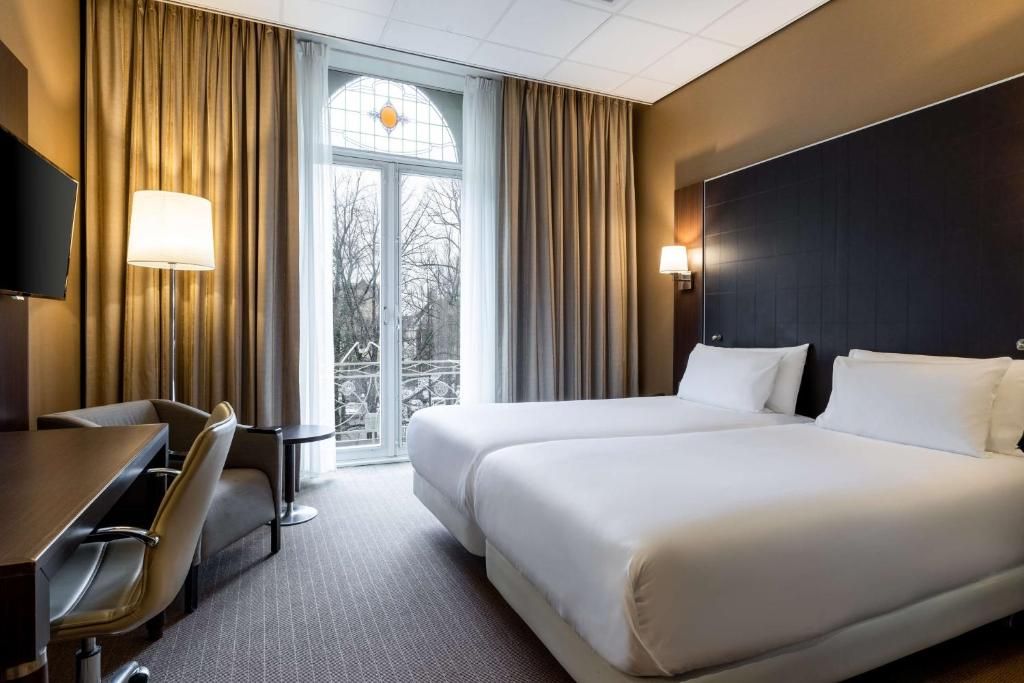 Comfortabele tweepersoonskamer in NH Centre Utrecht Hotel met uitzicht op de stad Utrecht.