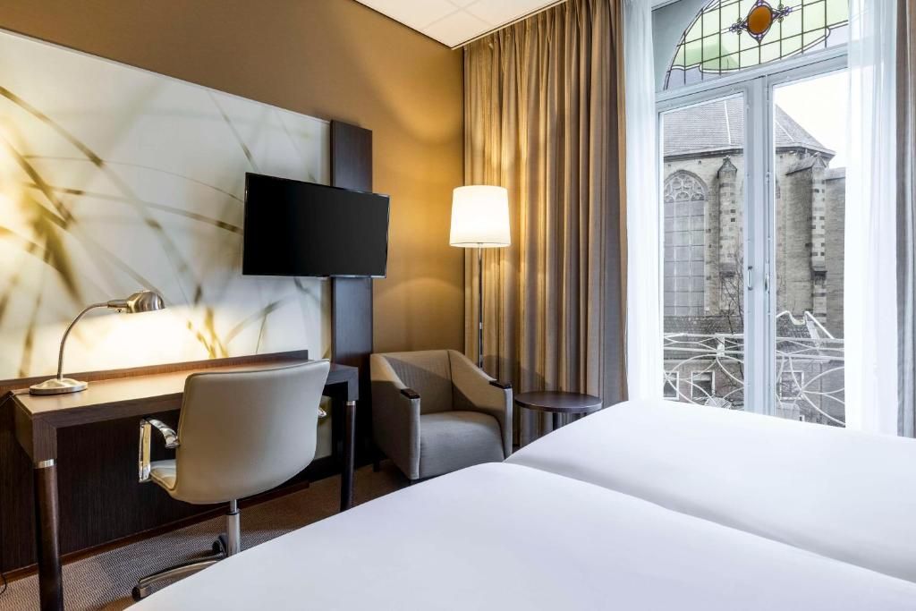 Elegant ingerichte kamer met balkon in NH Centre Utrecht Hotel, ideaal voor een stadsuitzicht in Utrecht.