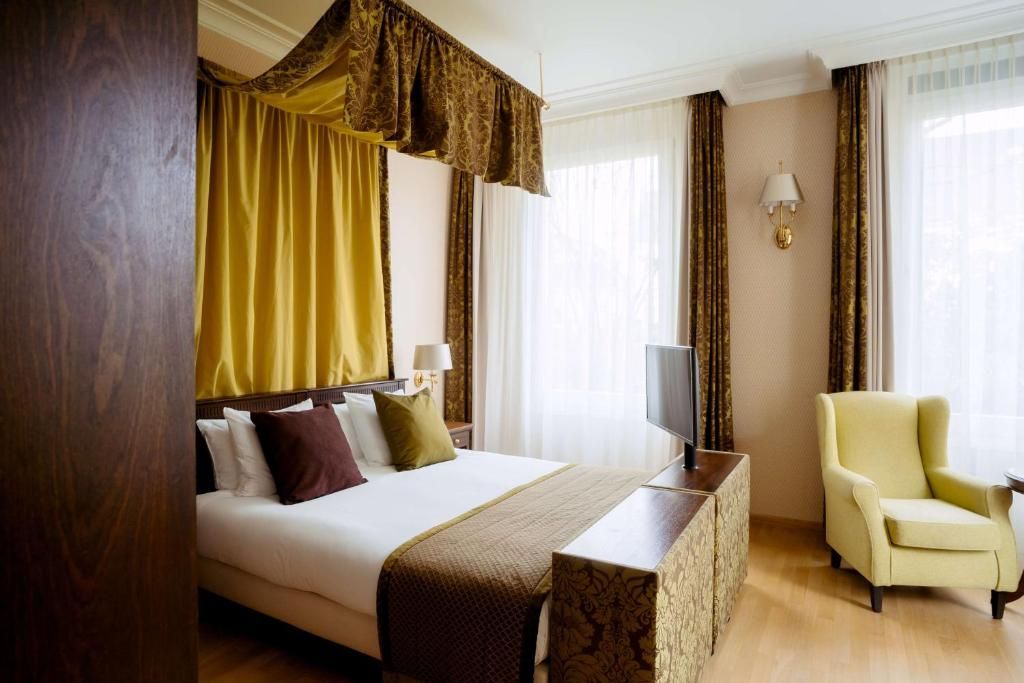 Stijlvolle slaapkamer met gordijnen in Grand Hotel Karel V, vakantieappartement Utrecht.