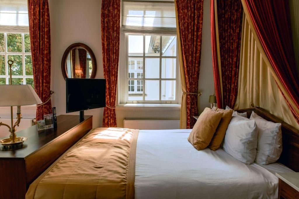 Klassieke slaapkamer met tv in Grand Hotel Karel V, vakantieappartement Utrecht.