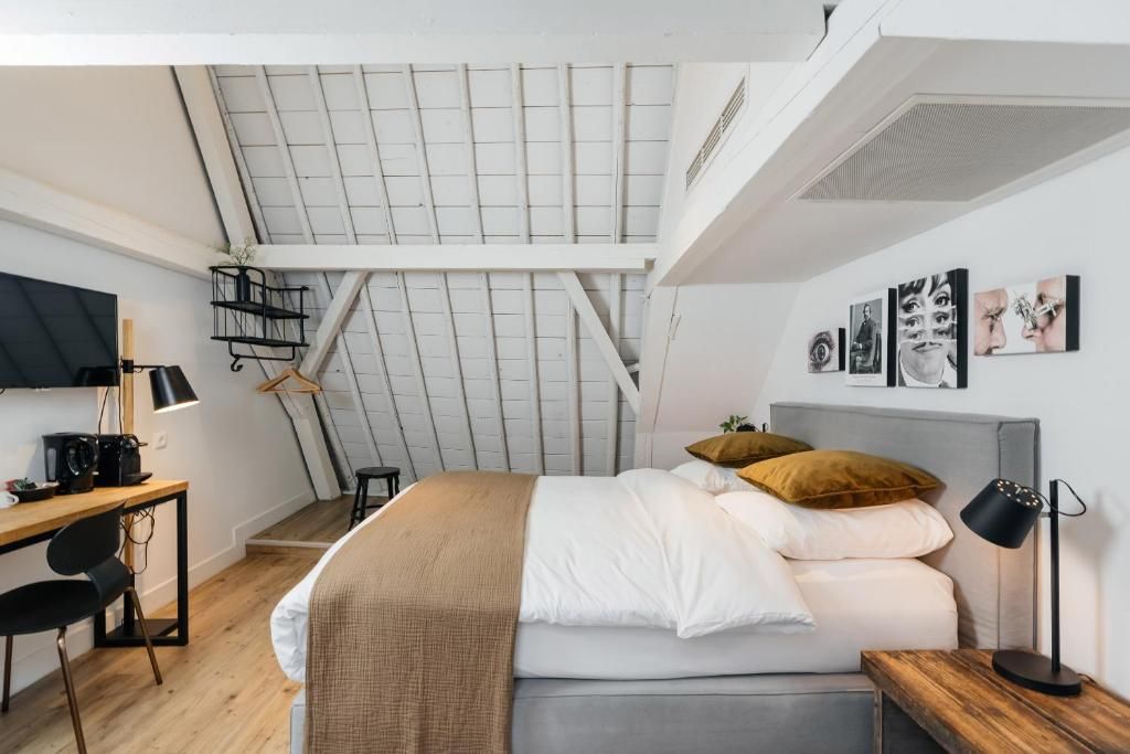 Ruime slaapkamer met houten balken in Eye Hotel Utrecht appartement.