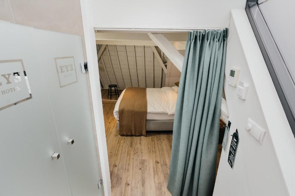 Uitzicht vanuit badkamer op slaapkamer in Eye Hotel Utrecht appartement.