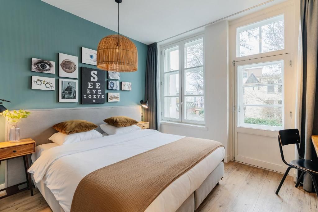 Sfeervolle slaapkamer met kunst en uitzicht in Eye Hotel Utrecht vakantiehuis.