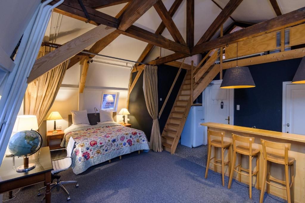 Ruime slaapkamer in Hotel Museumkwartier Utrecht, vakantie appartement met houten balken en gezellige sfeer.