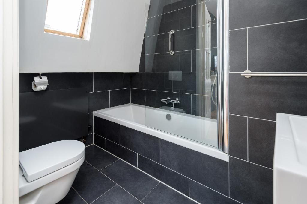 Moderne badkamer in Hotel Museumkwartier Utrecht, vakantie appartement in Utrecht met zwarte tegels.