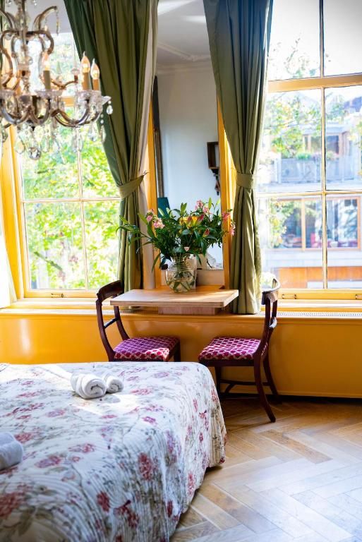 Zonnige zithoek in Hotel Museumkwartier Utrecht, vakantie appartement met bloemen en uitzicht.