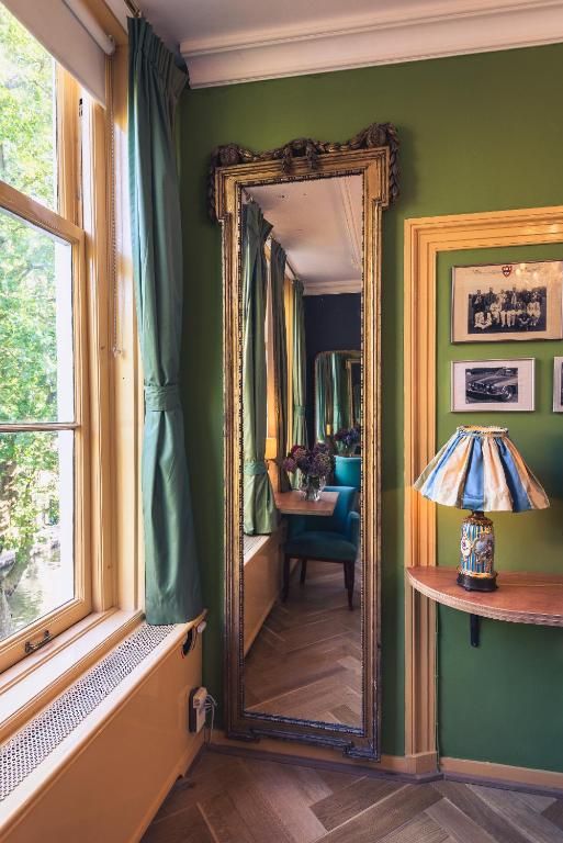 Stijlvolle spiegel en decor in Hotel Museumkwartier Utrecht, vakantie appartement met groene accenten.