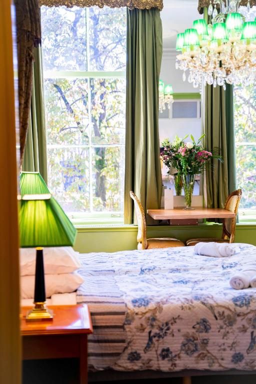 Romantische sfeer in Hotel Museumkwartier Utrecht, vakantie appartement met kroonluchter en bloemen.