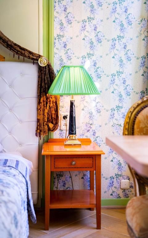 Gezellige hoek in Hotel Museumkwartier Utrecht, vakantie appartement met groene lamp en nachtkastje.