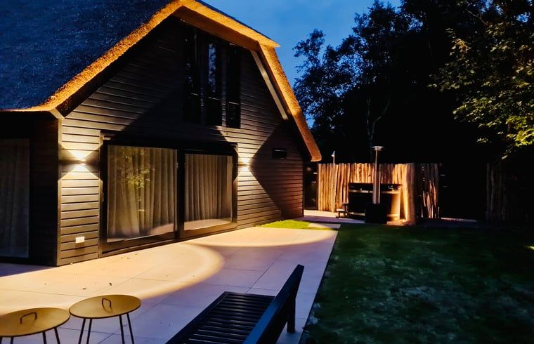 Moderne Terrasse am Ferienhaus in Ballum, Ameland, mit Abendbeleuchtung, ideal fuer gemuetliche Abende im Freien.