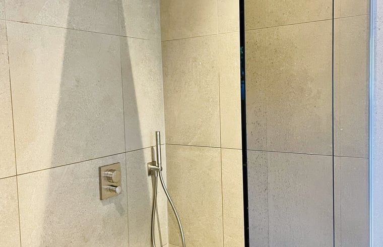 Modernes Badezimmer im Ferienhaus in Ballum, Ameland mit luxurioeser Dusche, perfekt fuer erfrischende Momente.