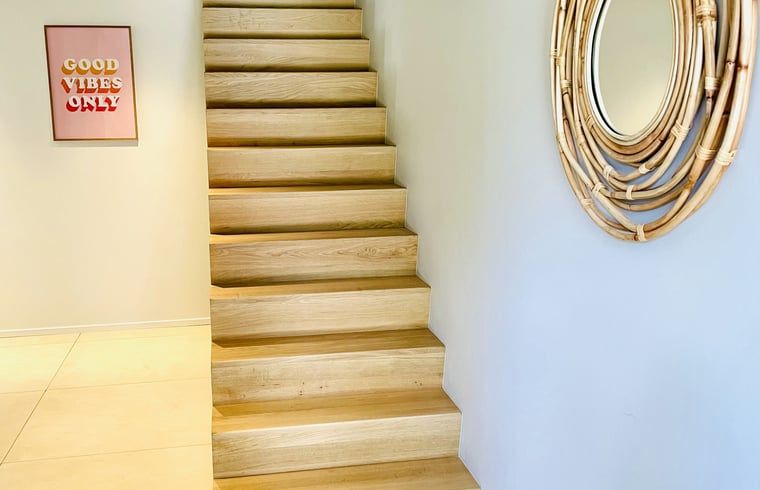 Die Holztreppe im Ferienhaus in Ballum, Ameland, fuehrt in das gemuetliche Obergeschoss, ideal fuer Familien.