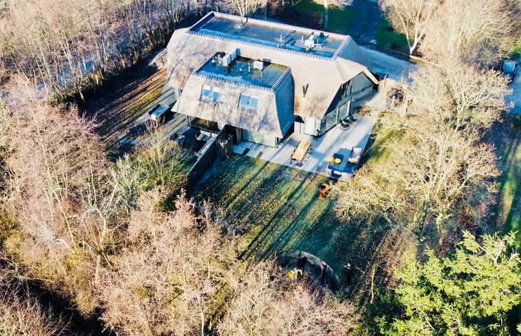 Drohnenaufnahme eines Ferienhauses in Ballum, Ameland, umgeben von Natur, perfekt fuer einen ruhigen Urlaub.