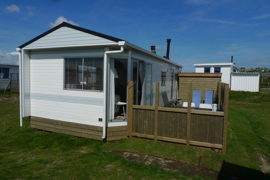 Island happiness chalet in Ballum, Ameland with sunny veranda and wooden terrace, ideal for relaxation on the Wadden Islands.