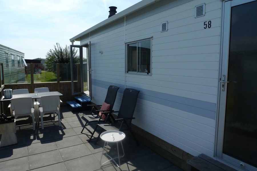 Private terrace of Eilandgeluk chalet in Ballum, Ameland, with seating and views of the beautiful Wadden Islands.