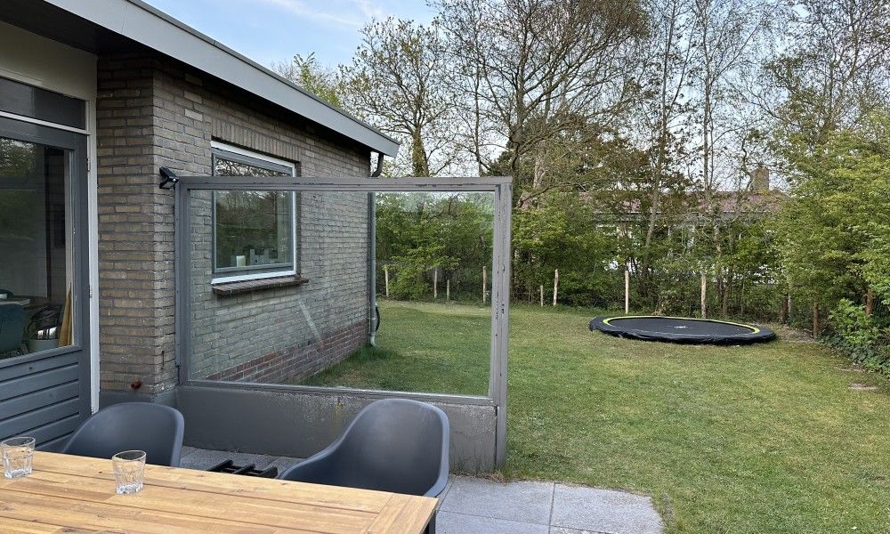 Tuin met trampoline bij Zeevonk bungalow in Ballum, Ameland, perfect voor gezinnen op de Waddeneilanden.