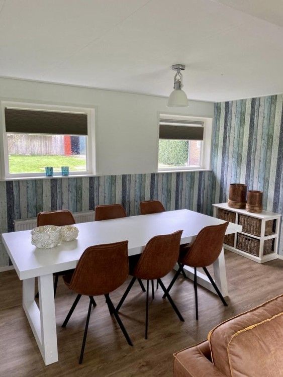 Esszimmer in Lodge 't Pandje, Ballum, Ameland mit grossem Tisch und bequemen Stuehlen, ideal fuer gemuetliche Mahlzeiten.