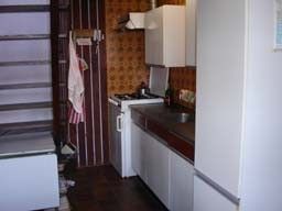 Kitchen of vacation home Suzan in Ballum, Ameland with retro decor, perfect for a cozy meal on the Wadden Islands.