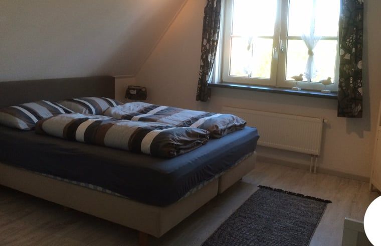 Ruime slaapkamer in Vakantiehuisje in Buren Ameland, biedt rust en comfort tijdens je verblijf op de Waddeneilanden.