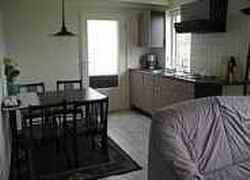 Gemuetlicher Innenbereich von app. Beekema in Buren, Ameland mit moderner Kueche und Essbereich, ideal fuer einen entspannten Aufenthalt.