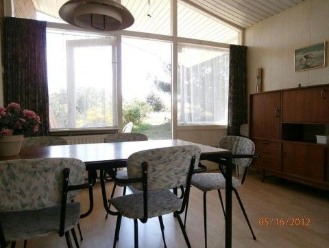 Essecke im Bungalow Dolphin, Buren, Ameland, mit Blick auf den Garten.