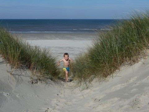 Ein Kind spielt in den Dnen am Bungalow Dolphin, Buren, Ameland, in der Nhe des Strandes.