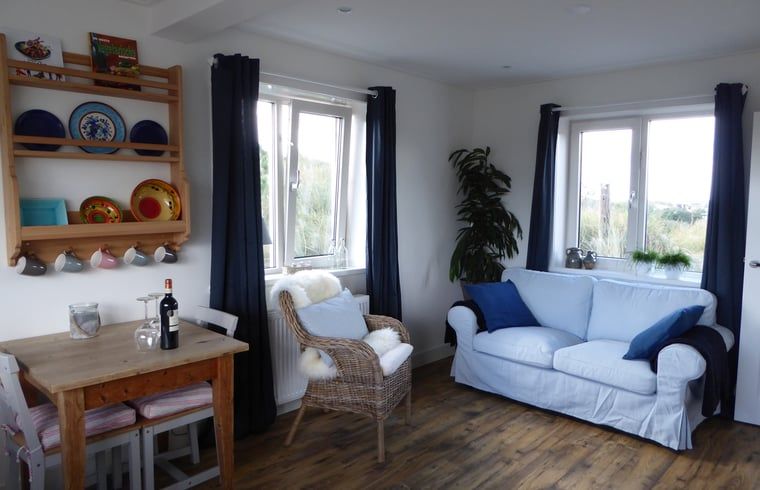 Gezellige woonkamer van Vakantiehuisje in Hollum op Ameland met comfortabele meubels en uitzicht op de natuur.