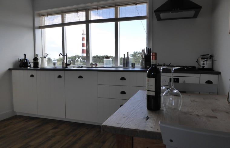 Keuken in Vakantiehuisje in Hollum op Ameland met uitzicht op de vuurtoren, perfect voor kookliefhebbers.