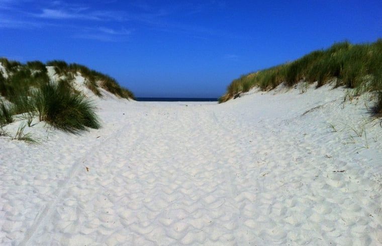 Toegang tot een afgelegen strandpad bij Vakantiehuisje in Hollum op Ameland, ideaal voor rustzoekers.