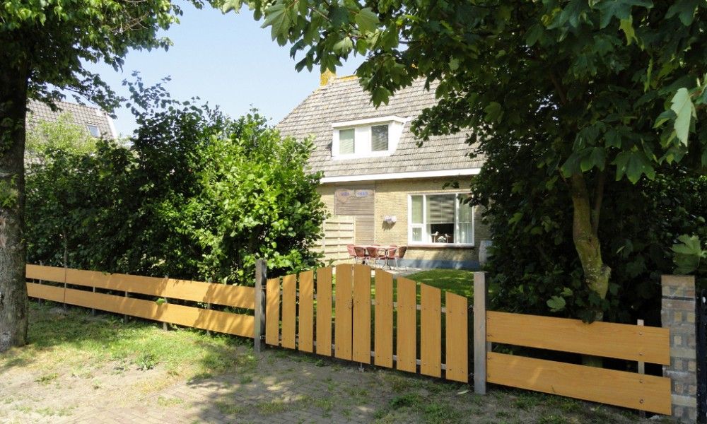 Oerd Ferienhaus in Hollum, Ameland mit sonniger Terrasse und gruener Umgebung.