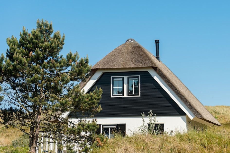 Engelsmanduinvilla 8 in Hollum, Ameland, een charmant vakantiehuis met rieten dak, omgeven door natuur in de Waddeneilanden.