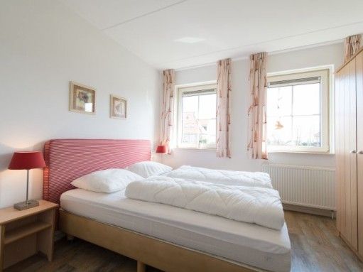 Bedroom in WEIDEVILLA B 6, Hollum, Ameland, vacation home with bright interior and comfortable beds.