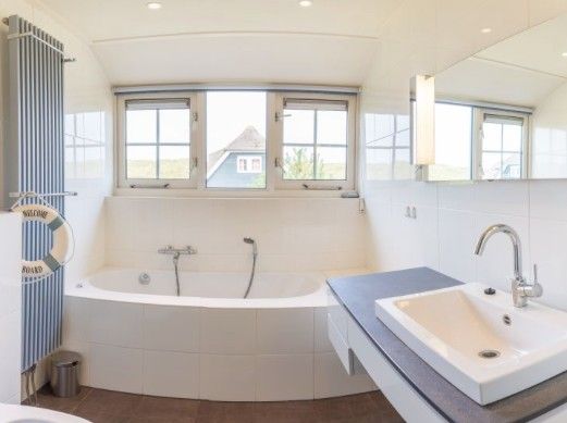 Luxury bathroom in ENGELSMANDUINVILLA DELUXE 6 vacation home in Hollum, Ameland with large bath and modern amenities.