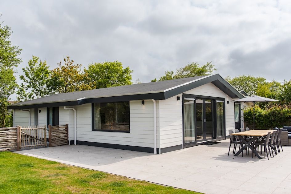 Ontspan op het terras van Finse Bungalow Luxe 8 in Hollum, Ameland. Geniet van de serene omgeving op de Waddeneilanden.