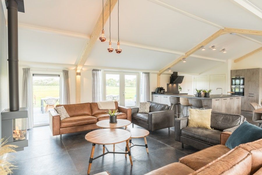 Geraeumiges Wohnzimmer im Bungalow Wagenschuur in Hollum, Ameland, mit moderner Einrichtung und Blick auf die Watteninseln.