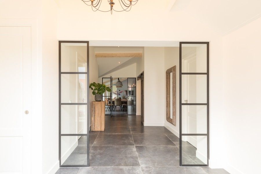 Stilvoller Eingang zum Ferienhaus Wagenschuur in Hollum, Ameland, mit Glastueren und rustikalem Look.